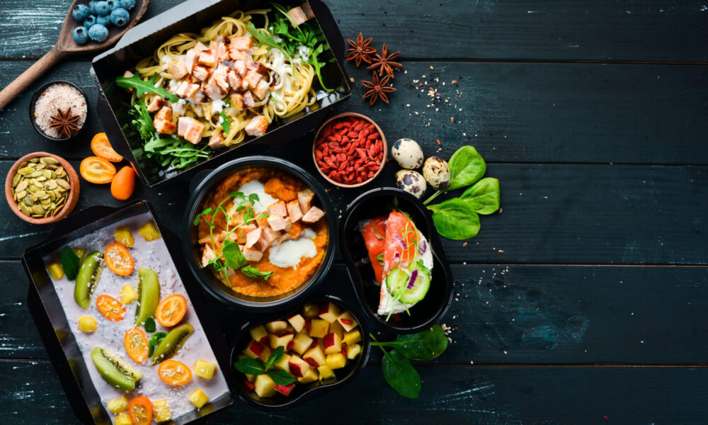 restaurant dish delivery. Catering, dinner dishes in boxes. Top view. Free space for your text. Rustic style.